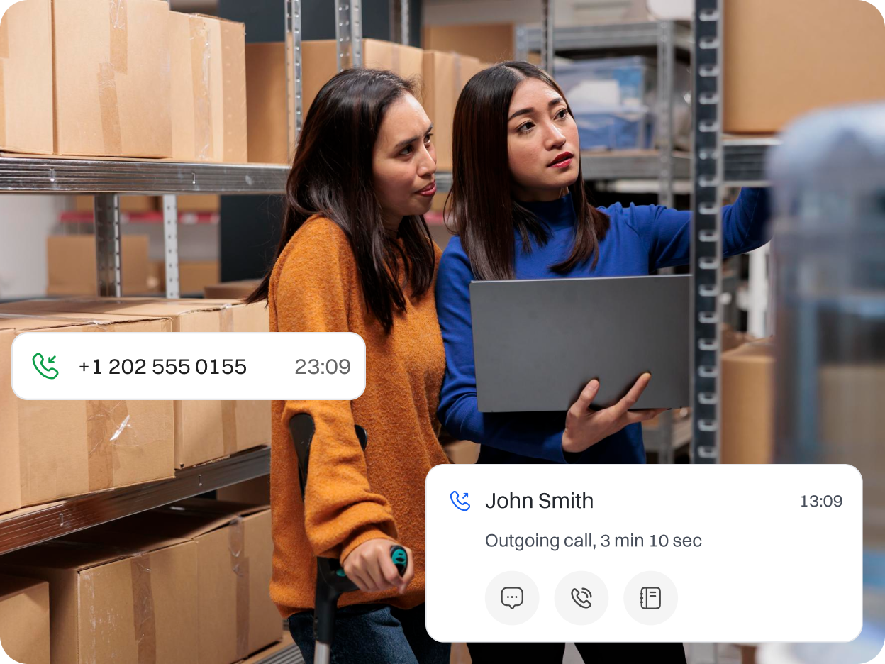 Two lady employees in Logistics space calling John smith to make sure packages are ready to be delivered.